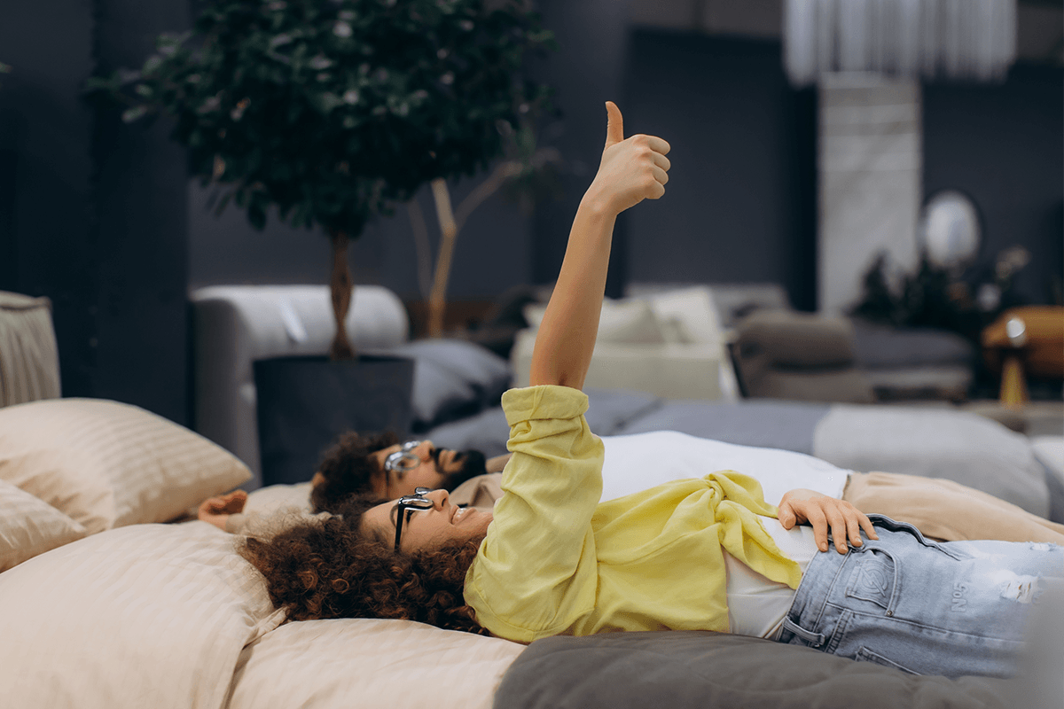 a couple in store trying out different mattress feels