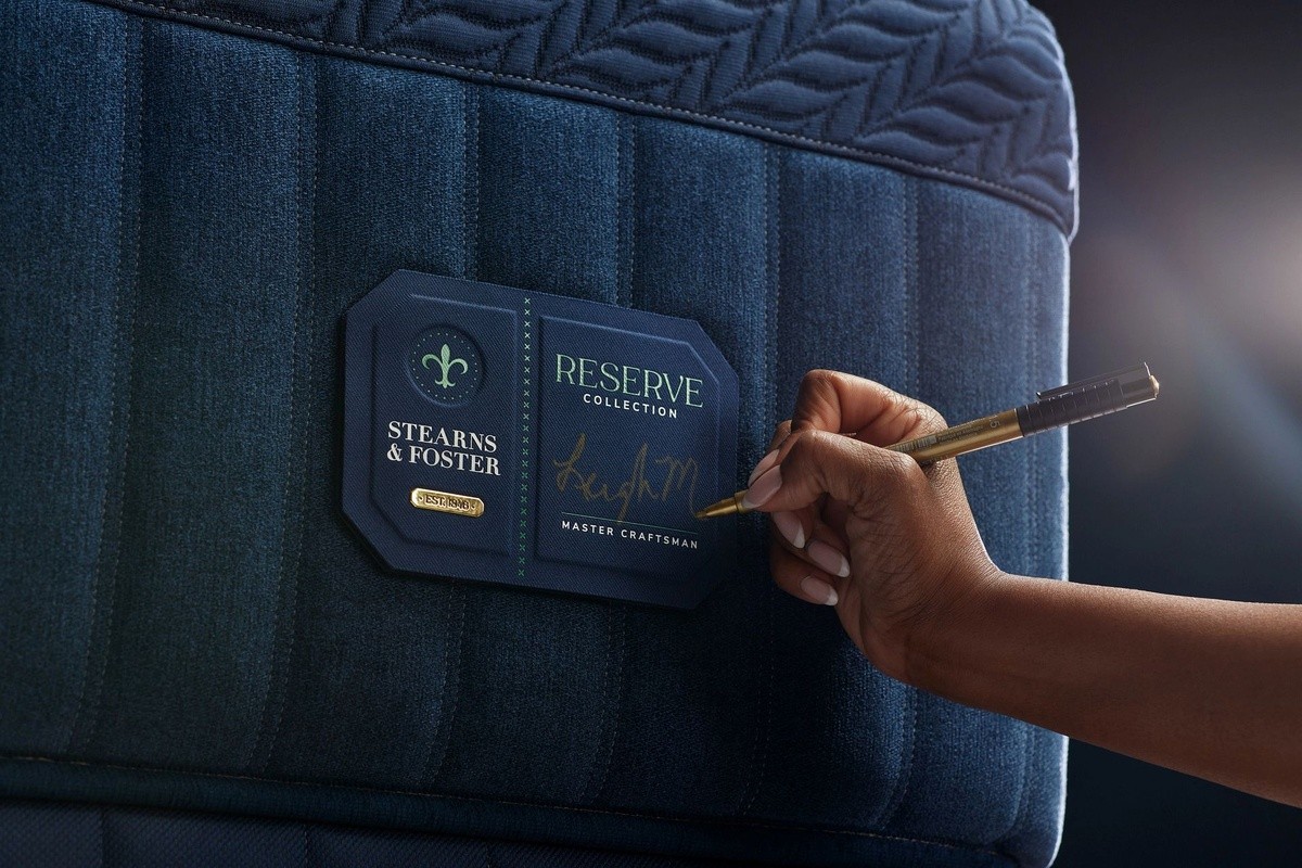 Hand signing a label on a reserve hybrid mattress