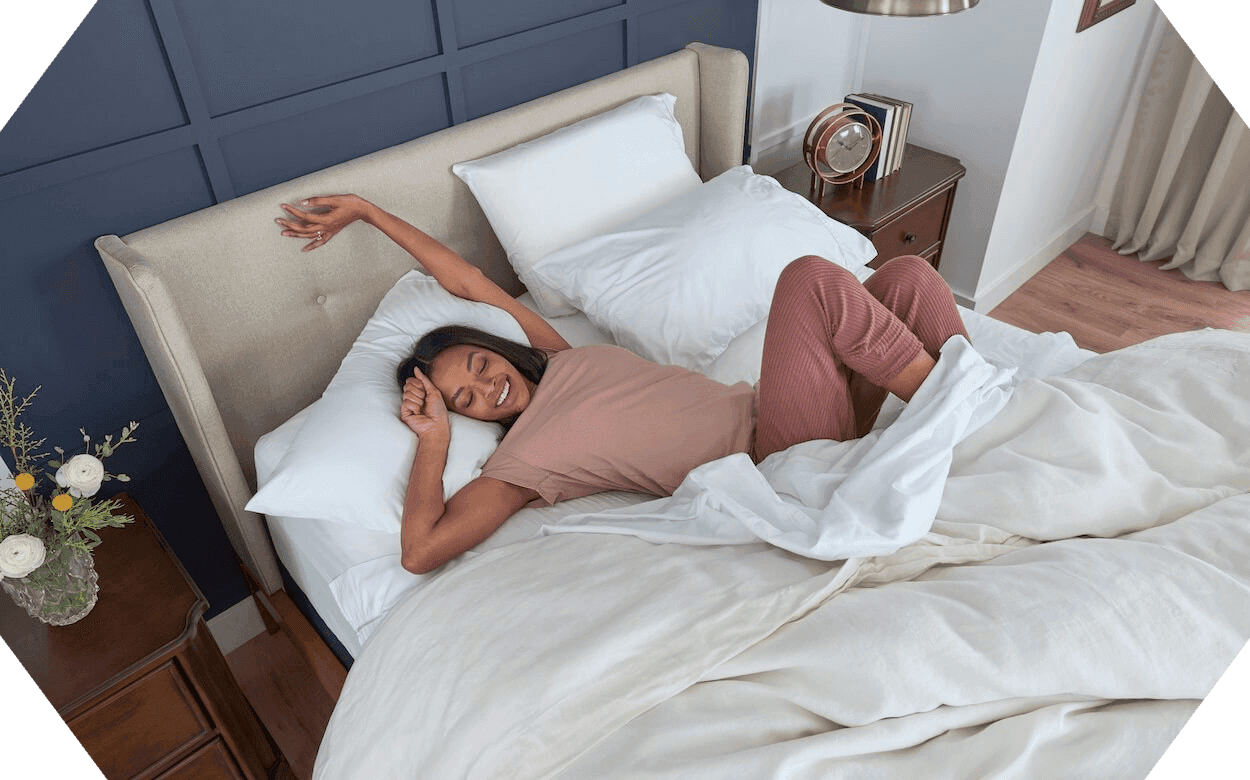 a woman streching out a dressed Stearns and Foster mattress