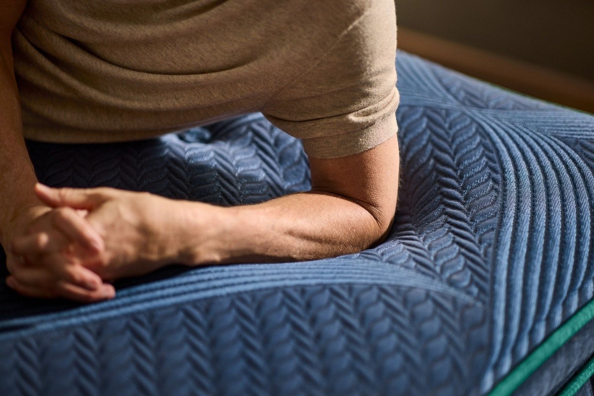 An elbow pressing down into a reserve mattress