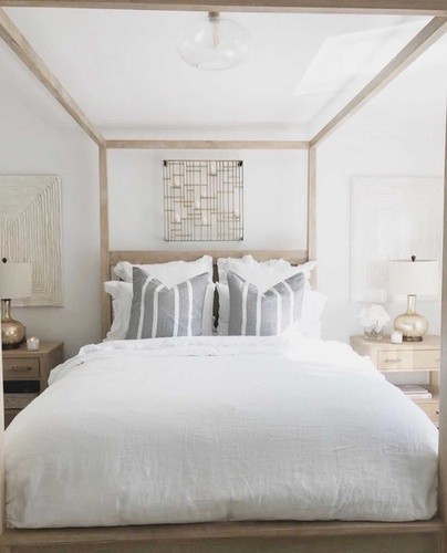 Stearns and Foster mattress on a wooden canopy frame with a white comforter and walls.jpg