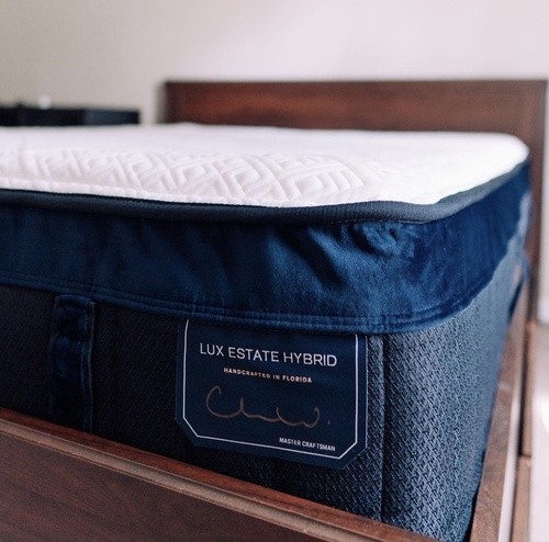 close up of Lux Estate Hybrid on a brown wooden bed frame