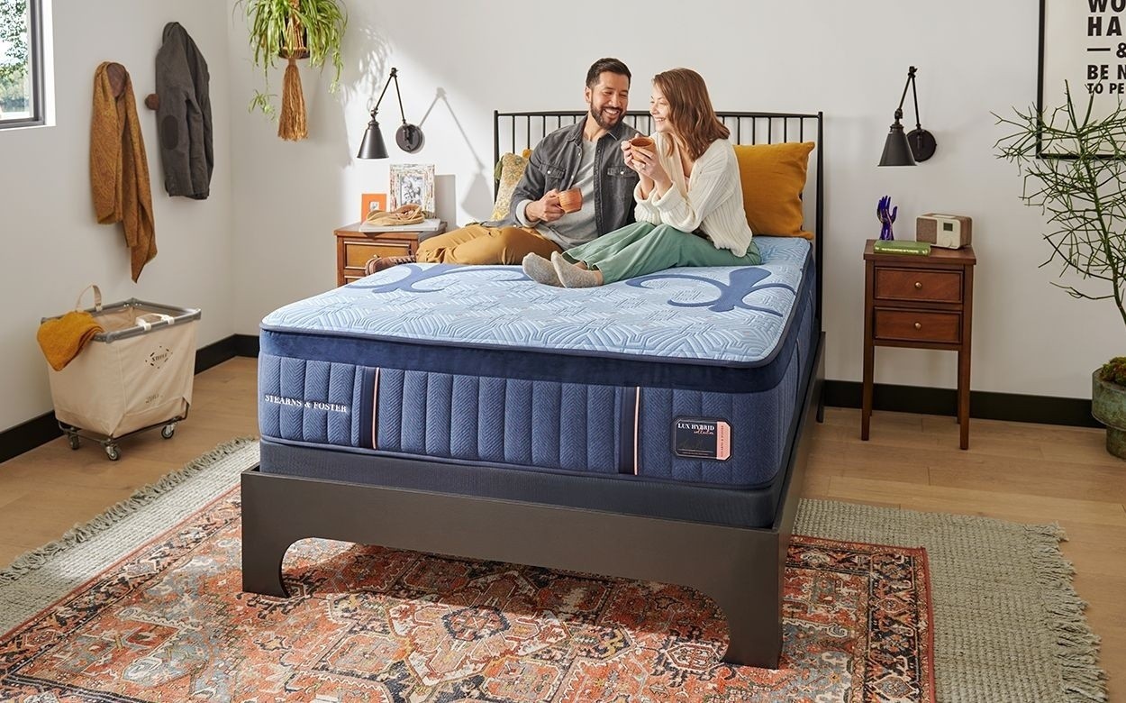 a couple sitting on a Lux Hybrid mattress