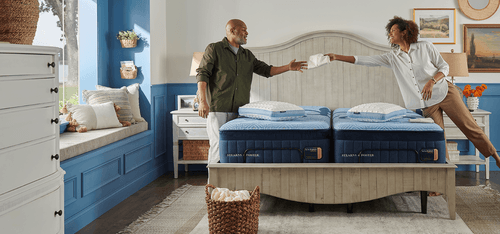 A couple putting their Stearns & Foster sheets on their mattress
